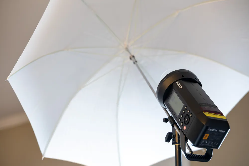 Close-up of the pro studio flash and large white shoot-through umbrella
